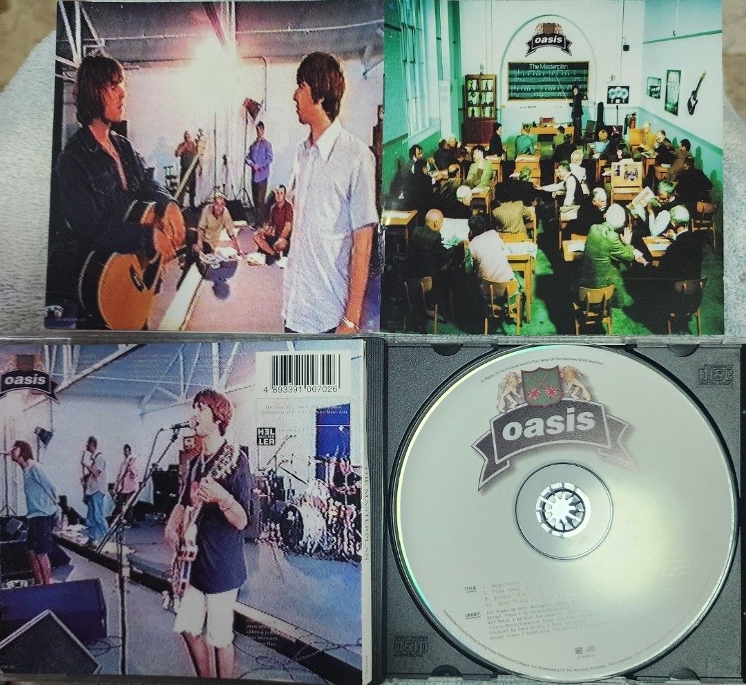 Oasis - The Masterplan (Category: CDs & DVDs) located in Cebu City. Submitted by g_roshamboo (Listing ID 1418883465, Image 2). Description: Oasis "The Masterplan" CD album. Includes the CD and the original booklet. The CD case shows some wear. The booklet contains information and a form. Features the band in a classroom setting on the cover..