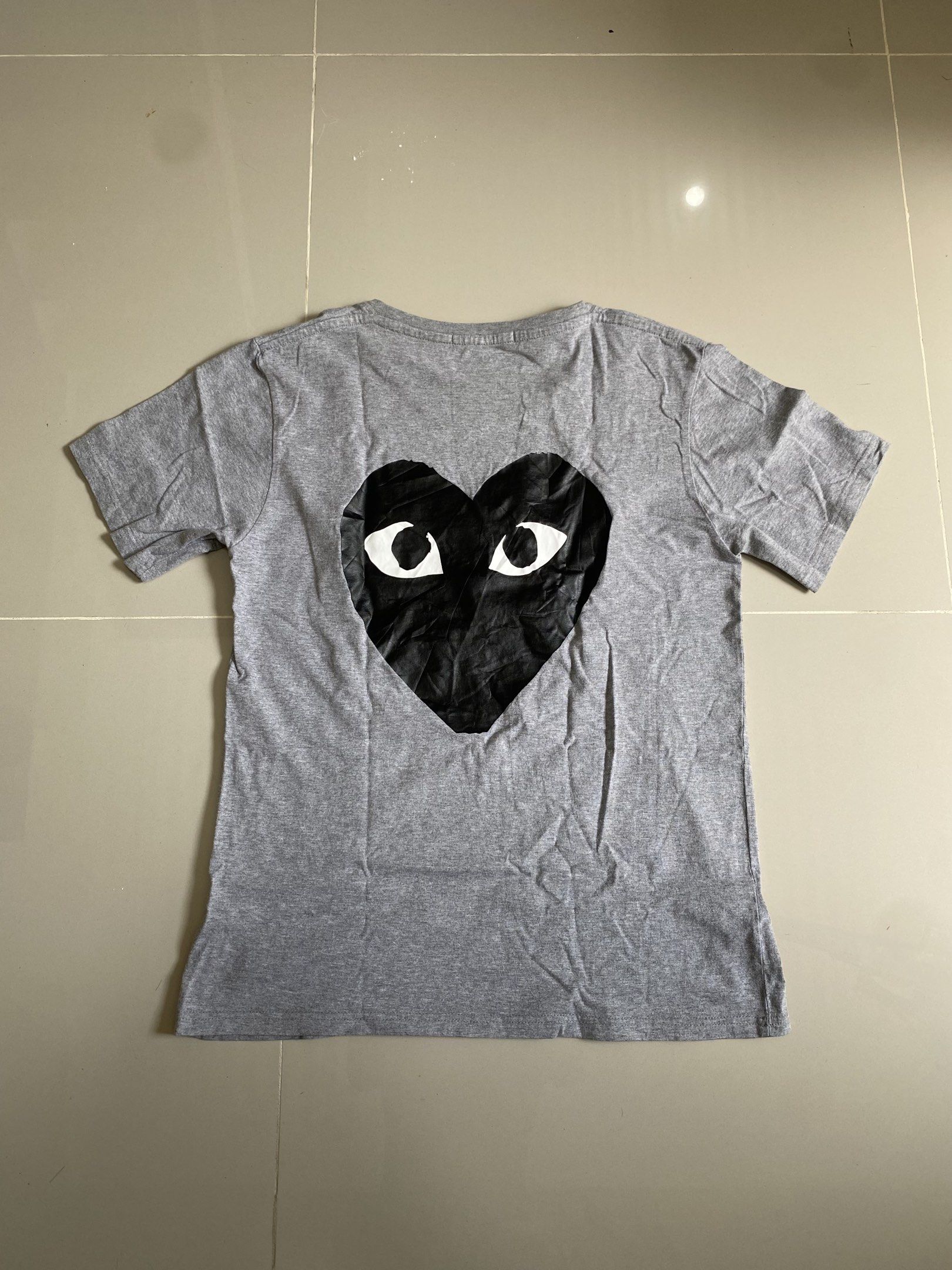 Play Comme des Garcons Grey T-shirt (Category: Tshirts & Polo Shirts ) located in Quezon City. Submitted by cointhrift (Listing ID 1418801642, Image 2). Description: - Grey Play Comme des Garcons T-shirt - Features brand logo on front - Iconic heart with eyes on back - Made in Japan - 100% Cotton - Crew neck - Short sleeves -19x26 dimension.