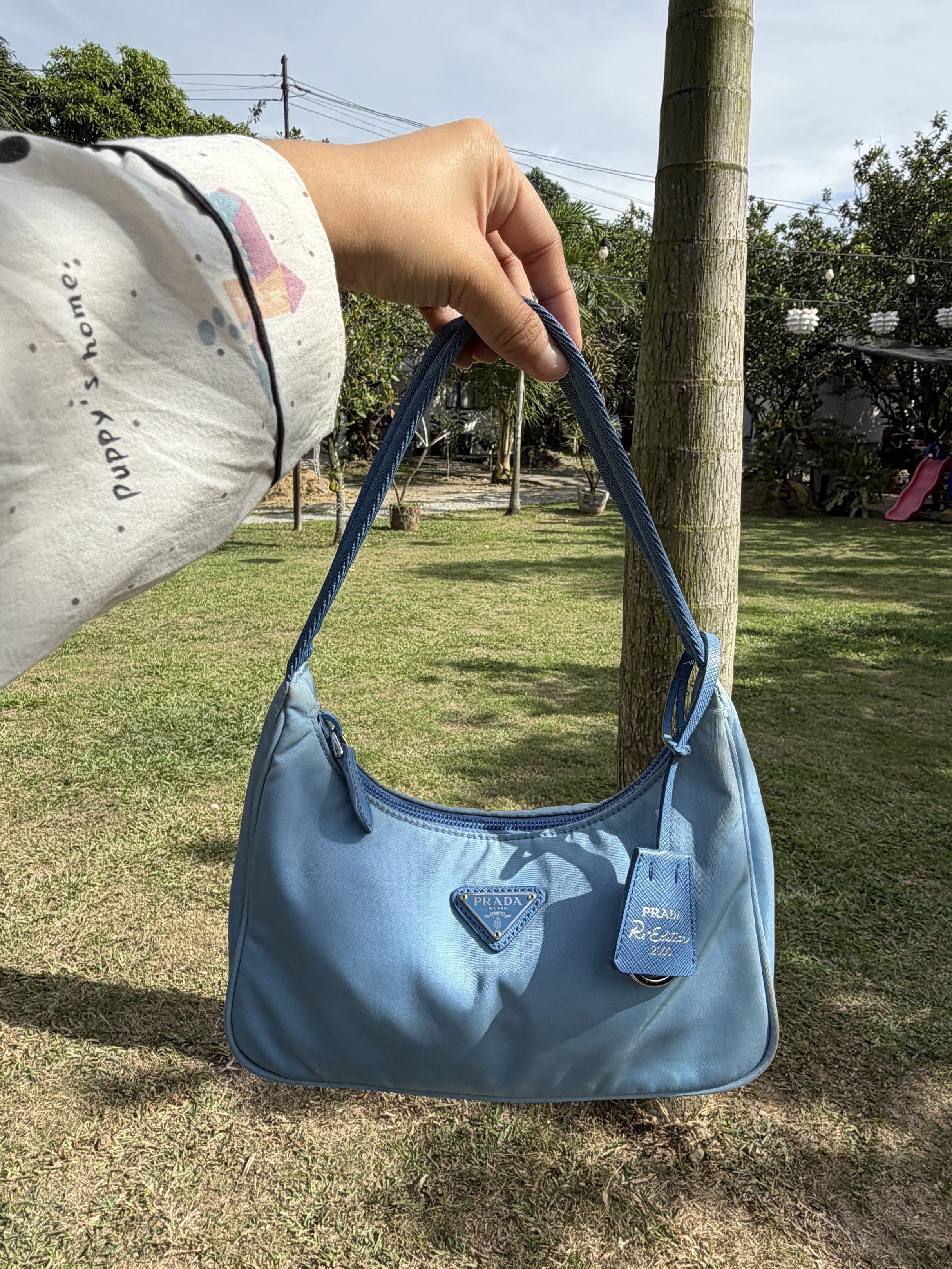Prada Re-Edition 2000 Mini Bag - Baby Blue (Category: Luxury Bags & Wallets) located in Plaridel. Submitted by marquezdiane (Listing ID 1418842586, Image 3). Description: - Authentic Prada Re-Edition 2000 mini bag - Baby blue nylon exterior - Minimal signs of usage dirt matatanggal sa bagspa - Matching blue handle - Detachable leather tag - Prada Milano interior label - Zipper closure - Made in Italy - Includes original prada dustbag.