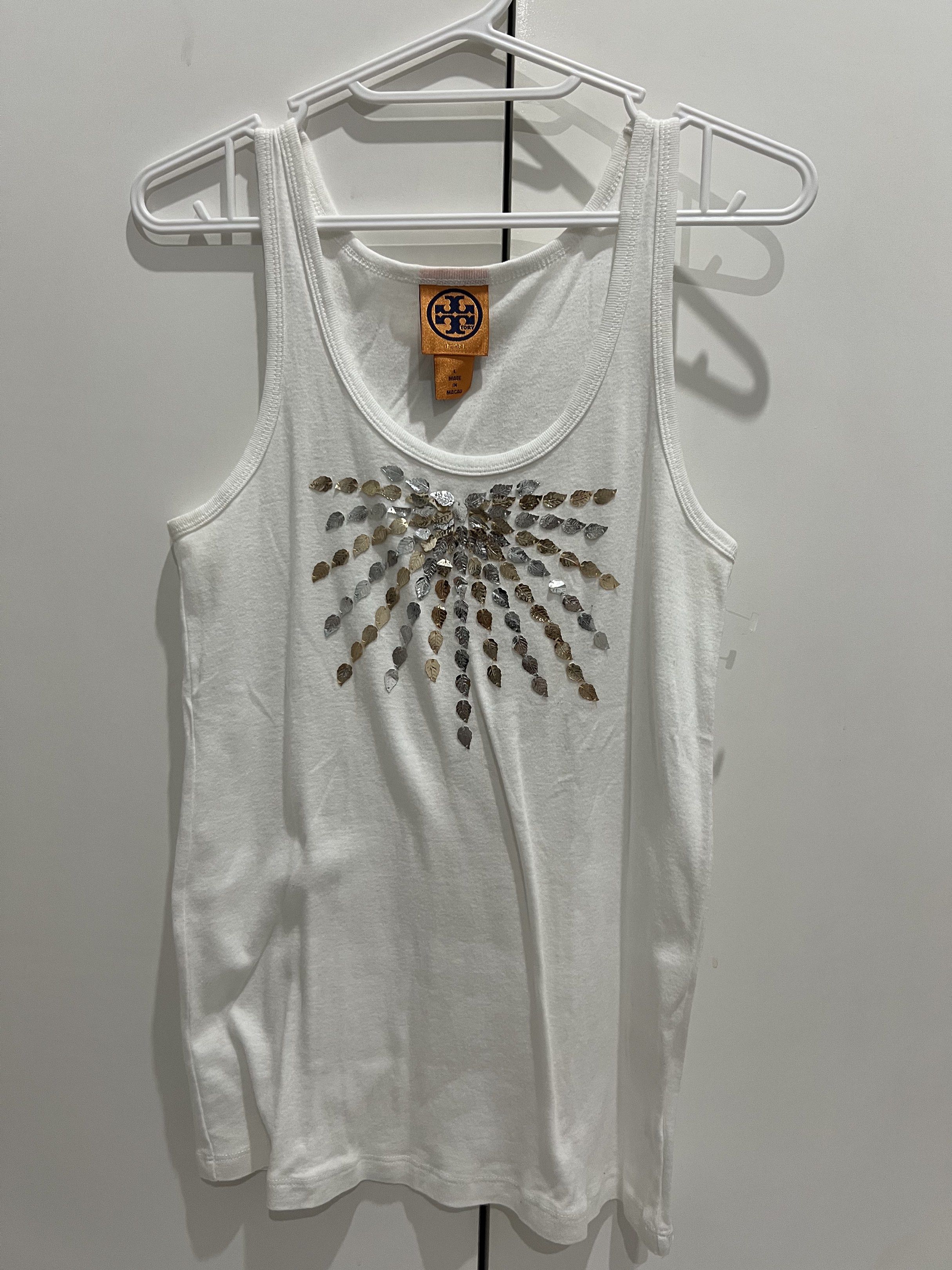 Tory Burch Embellished Tank Top - Size L (Category: Sleeveless) located in Cainta. Submitted by cendzz (Listing ID 1418876480, Image 1). Description: - Tory Burch tank top - White color - M built - Scoop neck, sleeveless design - Leaf-shaped embellishments - Sunburst pattern on chest - Soft, comfortable material.