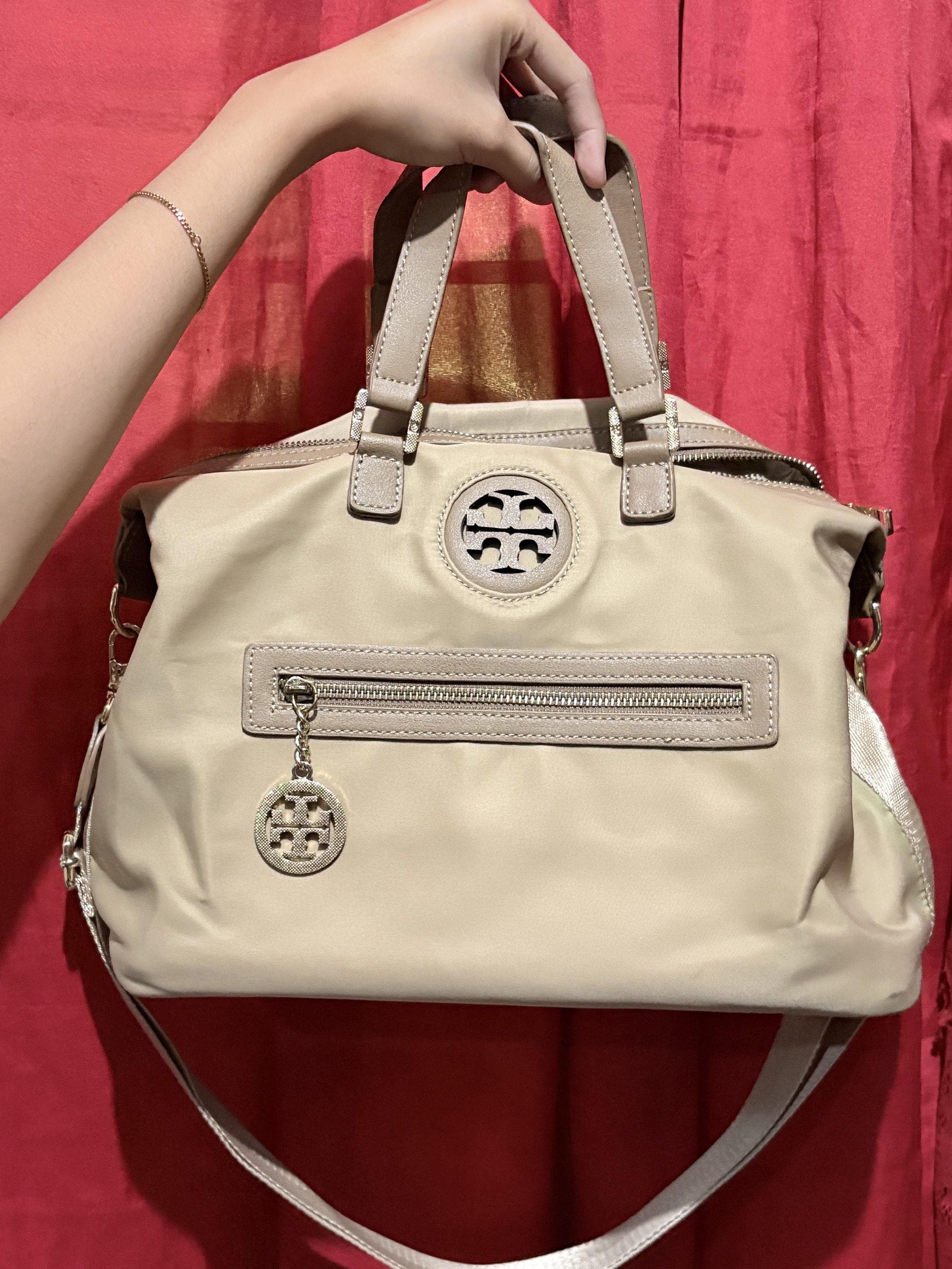 Tory Burch Satchel Bag (Category: Luxury Bags & Wallets) located in Manila. Submitted by cufflej (Listing ID 1418957361, Image 1). Description: - Tory Burch satchel bag - Beige exterior - Matching shoulder strap - Front zipper pocket - Tory Burch logo charm - Patterned interior lining - Metal Tory Burch label - Top handles - Detachable shoulder strap.