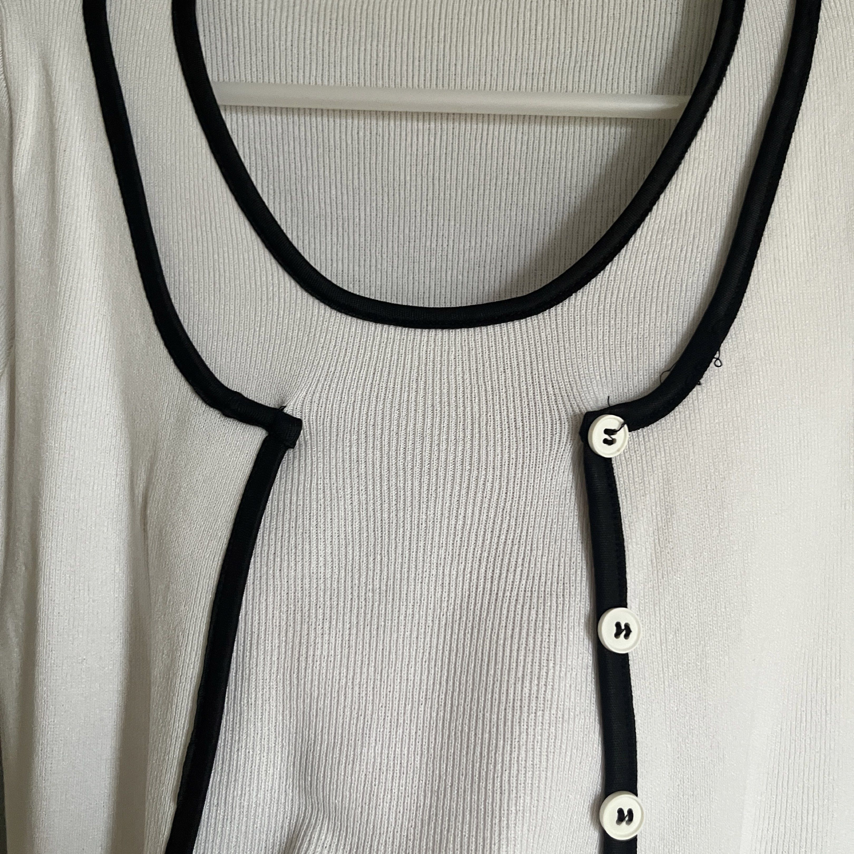 White Ribbed Top with Black Trim (Category: Sleeveless) located in Taguig. Submitted by _handydandy (Listing ID 1418928607, Image 2). Description: - White ribbed top - has a small flaw in the top right shoulder line (fixable) - price is negotiable - Black trim - Round neckline - Short sleeves - Cropped length - Button-up front - Knit material.