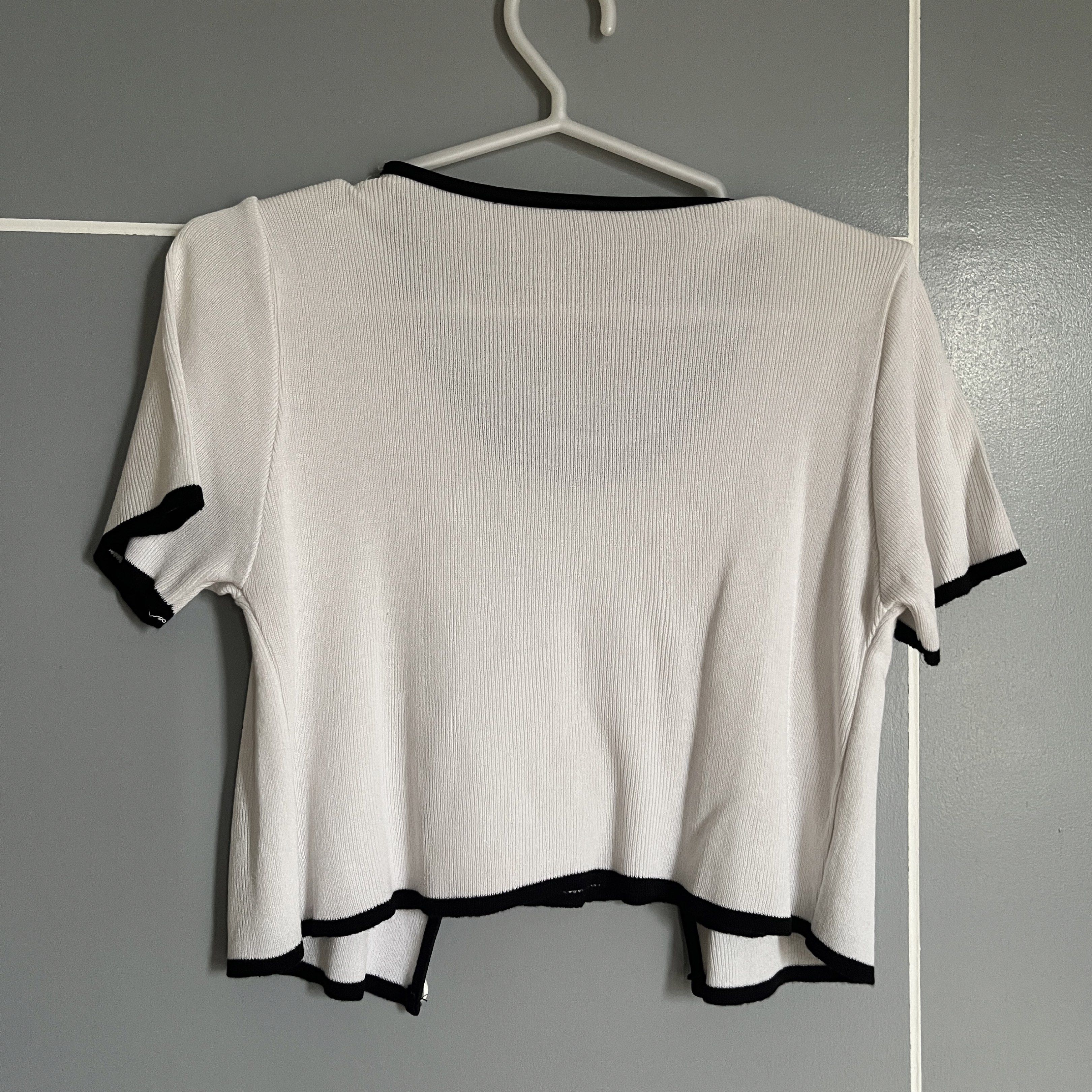 White Ribbed Top with Black Trim (Category: Sleeveless) located in Taguig. Submitted by _handydandy (Listing ID 1418928607, Image 3). Description: - White ribbed top - has a small flaw in the top right shoulder line (fixable) - price is negotiable - Black trim - Round neckline - Short sleeves - Cropped length - Button-up front - Knit material.