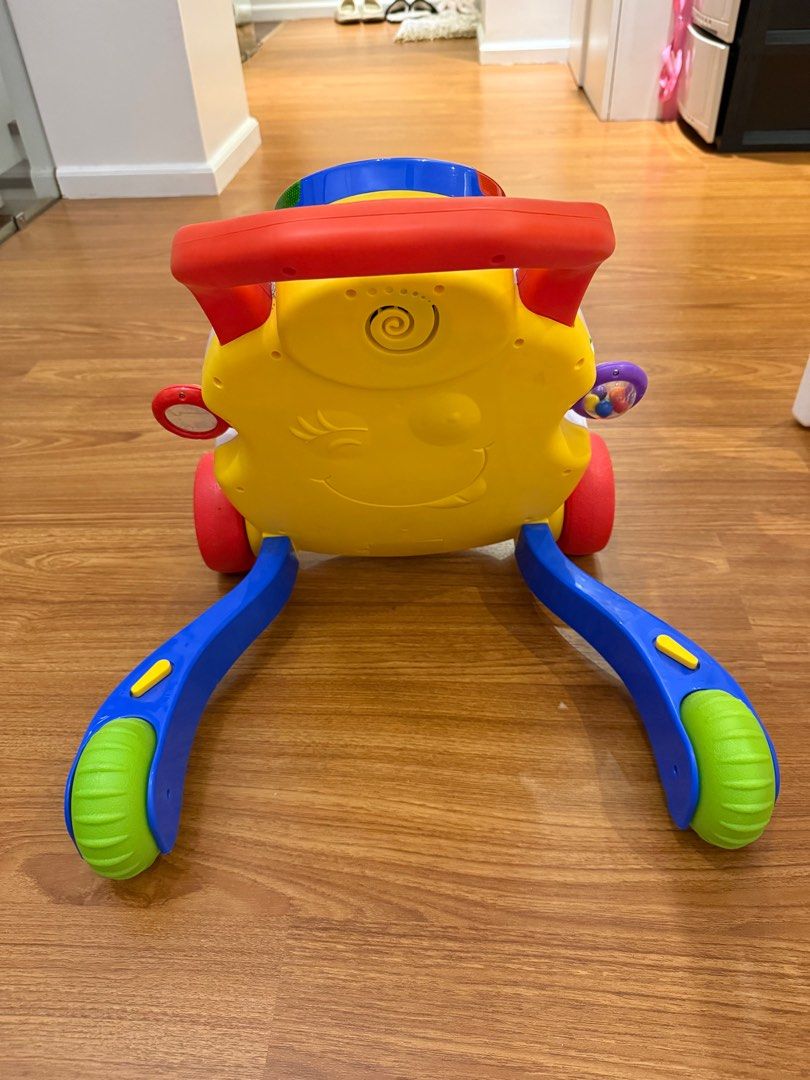 Chicco Walki Talky Baby Walker (Category: Infant Playtime) located in Quezon City. Submitted by ishaaaaang (Listing ID 1413589098, Image 3). Description: Condition 9/10 Bought at ₱5,990 - Chicco baby walker - Colorful design - Interactive elements - Handle for easy pushing - Playful front panel with shapes, buttons, and rolling ball - Wheels for mobility - Smiley face design - Designed to help babies learn to walk.