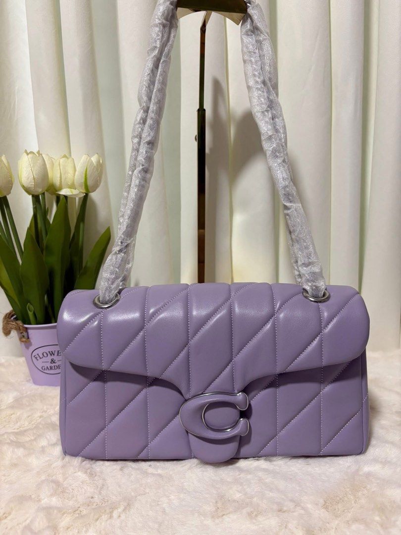 Coach Pillow Tabby Shoulder Bag 26 (Category: Luxury Bags & Wallets) located in San Fernando. Submitted by simplypurseandfragrances (Listing ID 1413477858, Image 1). Description: - Coach Pillow Tabby 26 Shoulder Bag - Stylish lavender color - Quilted design - Signature C clasp - Chain strap - Spacious interior with zip pocket - Includes Coach hang tag.