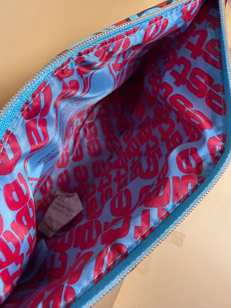 Estee Lauder Make Up Pouch (Category: Clutches) located in Pasig City. Submitted by chikaching (Listing ID 1413437034, Image 2). Description: Estee Lauder make up pouch features a vibrant red exterior with a blue floral design. The interior is lined with a light blue fabric and a repeating red text pattern. It has a zipper closure and a wrist strap. Slightly negotiable.