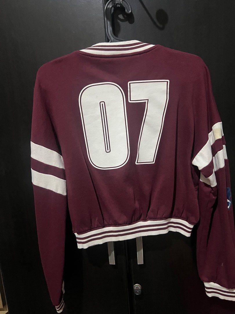 H&M Harry Potter Varsity Jacket (Category: Babies & Kids Fashion) located in San Mateo. Submitted by junked (Listing ID 1413616495, Image 3). Description: Maroon H&M varsity jacket with Harry Potter patches. Features white stripes on the sleeves and a "07" on the back. The jacket has a cropped fit and a button-up front. Size is EUR 146/152, US 12/14, CA 10-12A, CN 150/76, MX 10-12A, AUS 11-12, UK 10-12Y. Some wear and tear is visible on the sleev