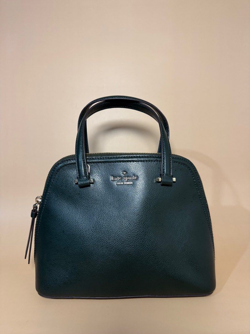 Kate Spade Green Leather Handbag (Category: Luxury Bags & Wallets) located in Pasig City. Submitted by chikaching (Listing ID 1413436534, Image 2). Description: - Kate Spade handbag - Dark green leather exterior - Top handle and detachable shoulder strap - Zip closure - Small zip pocket - Kate Spade logo on front - Slightly Negotiable.