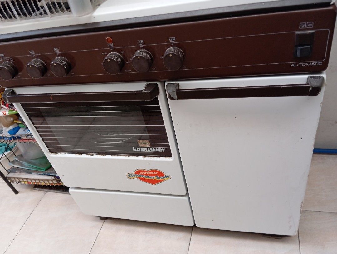 LaGermania Gas Range with Oven (Category: Ovens & Toasters) located in Muntinlupa City. Submitted by anythingboutiquebylala (Listing ID 1413497116, Image 1). Description: Germania gas range features a cooktop with four gas burners and one electric burner. It includes an oven with a glass door and a broiler. The control panel has knobs for burner and oven temperature adjustments. The range has a brown and white color scheme. It has an automatic ig