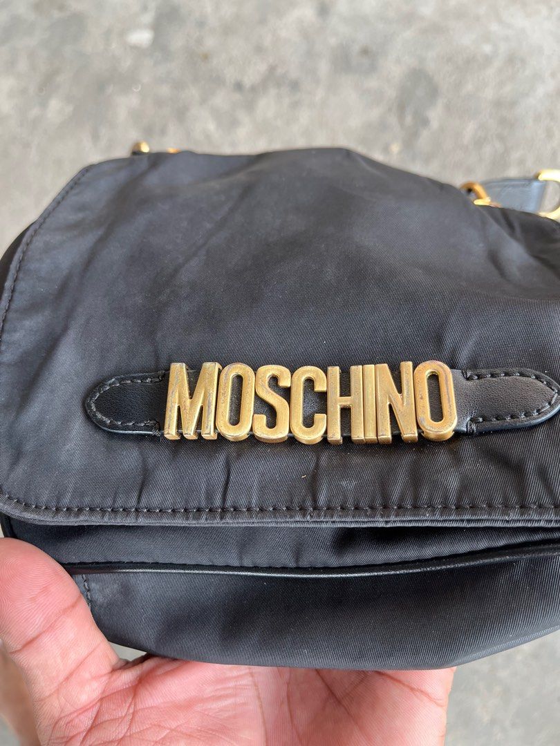 Moschino Black Nylon Shoulder Bag (Category: Luxury Bags & Wallets) located in General Santos City (Dadiangas). Submitted by thiftnibadi3 (Listing ID 1413492732, Image 3). Description: - Moschino black nylon shoulder bag - Gold-tone logo and hardware - Detachable shoulder strap - Interior pocket with Moschino Milano label - Zipper closure - Made of 100% nylon.