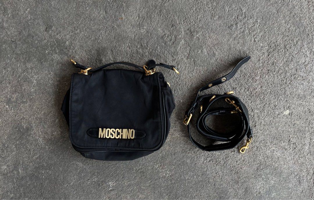 Moschino Black Nylon Shoulder Bag (Category: Luxury Bags & Wallets) located in General Santos City (Dadiangas). Submitted by thiftnibadi3 (Listing ID 1413492732, Image 1). Description: - Moschino black nylon shoulder bag - Gold-tone logo and hardware - Detachable shoulder strap - Interior pocket with Moschino Milano label - Zipper closure - Made of 100% nylon.