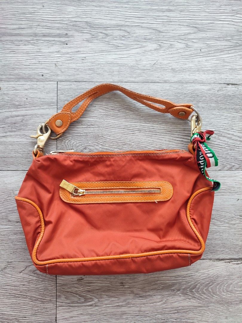 Orobianco Orange Handbag (Category: Luxury Bags & Wallets) located in Pasig City. Submitted by vintage.thrifttph (Listing ID 1413478482, Image 2). Description: - Orange Orobianco handbag - Top handle design - Gold-tone zipper and logo - Includes a small Italian flag charm - Fabric lining with brand name - Interior pocket with brand tag Pickup: 📍 Kapasigan, Pasig Shipping via: 🚚 Lalamove / JNT.