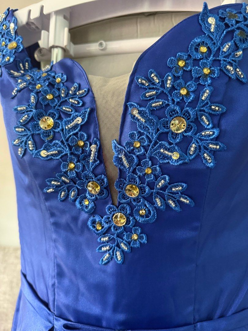 Royal Blue Formal Ball Gown (Category: Evening dresses & gowns) located in Las Pinas. Submitted by bitsnfinds (Listing ID 1413484363, Image 1). Description: Worn once, dry-cleaned. No stains or damage. Well-kept in storage cabinet. Royal royal blue formal gown featuring gold sequined and beaded lace appliqués on the deep V-neckline and shoulders. The dress has a fitted bodice and a long, flowing ball gown style skirt, made of satin formal fabric.