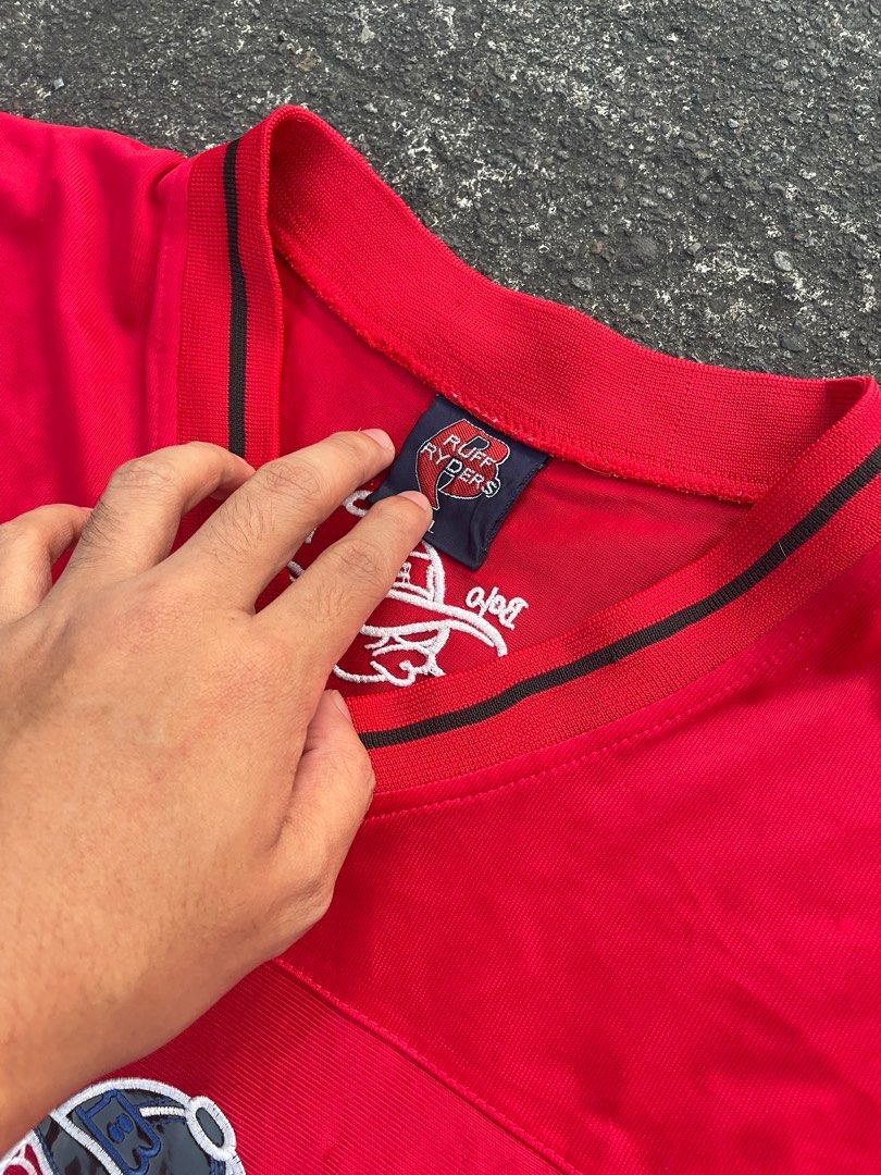 Ruff Ryders Bolo Graphic T-shirt (Category: Tshirts & Polo Shirts ) located in Manila. Submitted by alxanderctlan (Listing ID 1413508835, Image 3). Description: - Red Ruff Ryders T-shirt - Features a Bolo graphic on the front - V-neck design - Black stripes on sleeves and collar - Graphic of a person wearing a cap - Brand logo on collar - Back of shirt has cap graphic and "SOHK" logo.