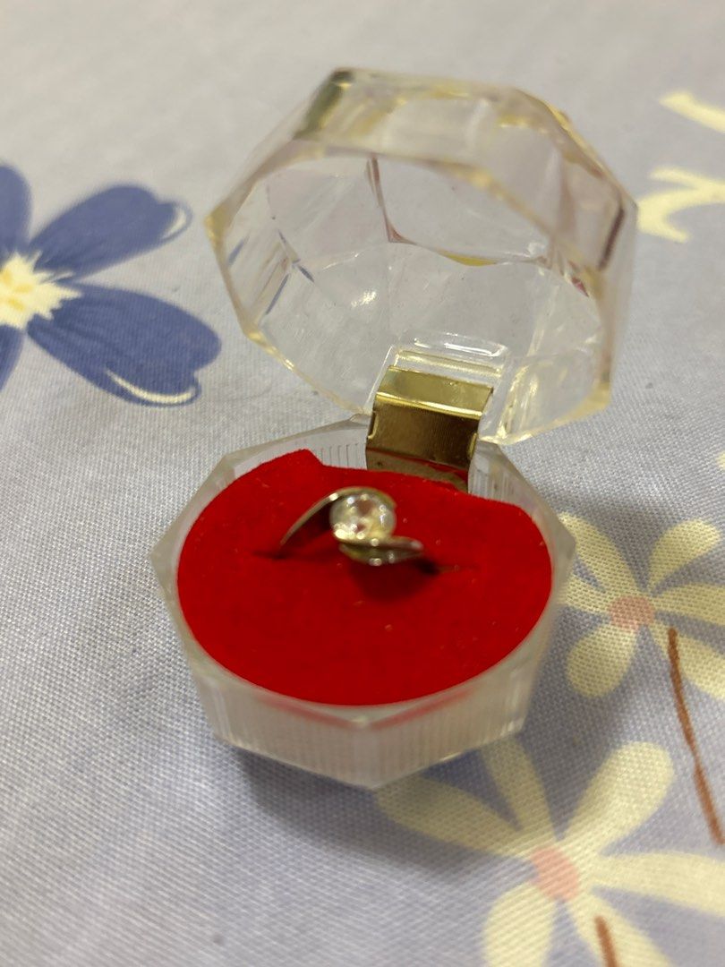 Silver Ring with Clear Stone (Category: Rings) located in Quezon City. Submitted by luxgoals (Listing ID 1413517830, Image 1). Description: - Silver ring with a clear, round-cut stone - Unique swirling band design - Comes with a clear, faceted box - Red velvet interior - Classic and elegant - Ideal gift or addition to a jewelry collection.