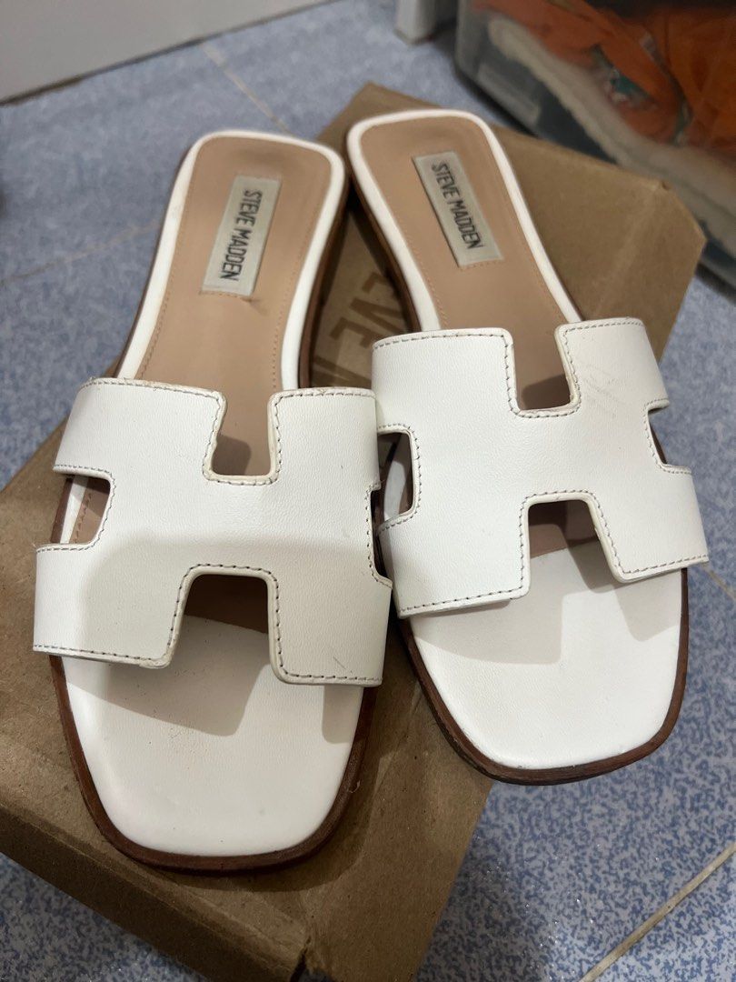 Steve Madden White Sandals (Category: Flats & Sandals) located in Zaragoza. Submitted by lerryparungao (Listing ID 1413466193, Image 1). Description: - White Steve Madden sandals - H-shaped design - Brown sole - Light tan footbed - Includes brown cardboard box.