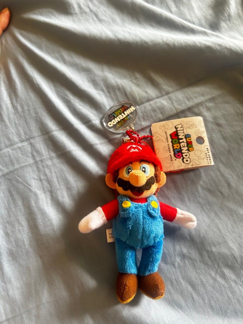 Super Nintendo World Mario Plush Keychain (Category: Character Goods) located in Taguig. Submitted by tidytitan (Listing ID 1413476514, Image 1). Description: - Authentic Mario plush keychain from Super Nintendo World. - Features Mario in his iconic red cap and blue overalls. - Includes attached tag. - Ideal for Nintendo and Mario collectors. - Perfect as a bag charm or a fun addition to your collection..