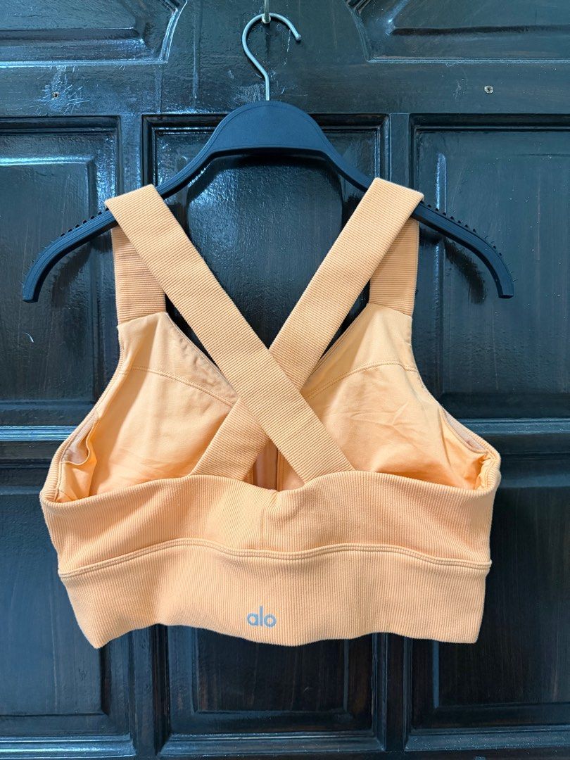Alo Emulate Bra (Category: Activewear) located in Manila. Submitted by haveago0dthrift (Listing ID 1413793699, Image 3). Description: - Alo Yoga sports bra - Ribbed texture - Crossback design - V-neckline - Supportive band - Light orange color - Size: Large - Alo logo visible - Made in Vietnam -Width 28-34 -Length 14.