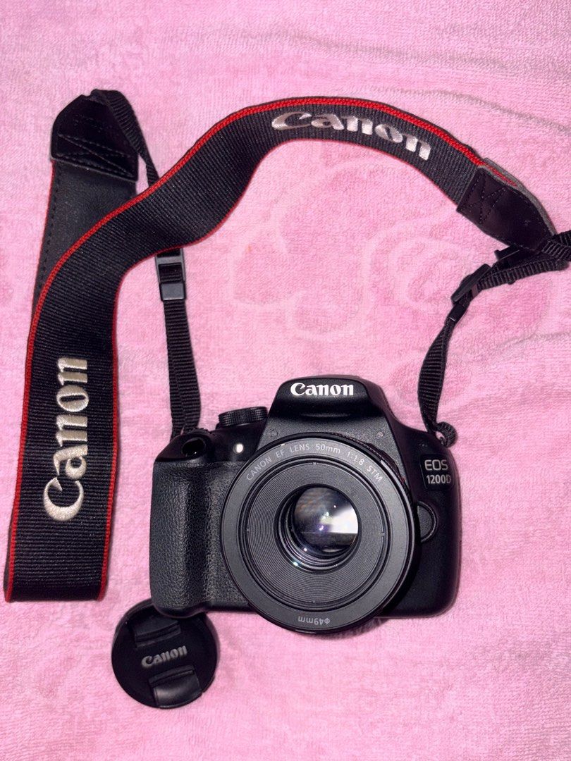 Canon EOS 1200D with 50mm Lens (Category: Cameras) located in Manila. Submitted by love.hazey (Listing ID 1413653627, Image 1). Description: - Canon EOS 1200D DSLR camera - Includes 50mm f/1.8 STM lens - Comes with Canon neck strap and lens cap - Black camera body and lens - Lens features AF/MF switch - Camera has a mode dial and various buttons - Lens has a 49mm filter thread - No damages, No replacement parts - 100% original - With Bag and char