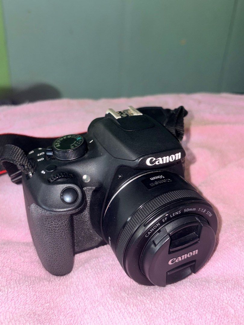 Canon EOS 1200D with 50mm Lens (Category: Cameras) located in Manila. Submitted by love.hazey (Listing ID 1413653627, Image 2). Description: - Canon EOS 1200D DSLR camera - Includes 50mm f/1.8 STM lens - Comes with Canon neck strap and lens cap - Black camera body and lens - Lens features AF/MF switch - Camera has a mode dial and various buttons - Lens has a 49mm filter thread - No damages, No replacement parts - 100% original - With Bag and char