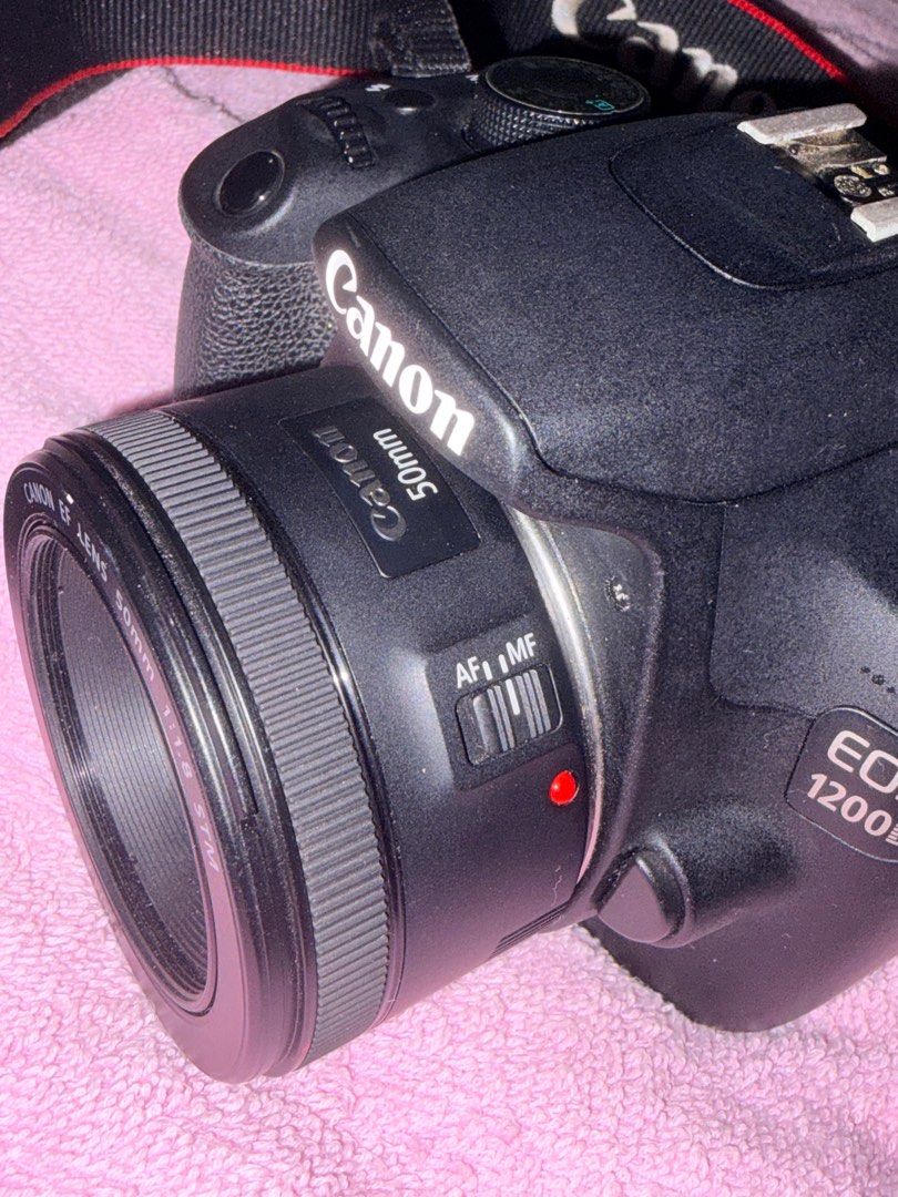 Canon EOS 1200D with 50mm Lens (Category: Cameras) located in Manila. Submitted by love.hazey (Listing ID 1413653627, Image 3). Description: - Canon EOS 1200D DSLR camera - Includes 50mm f/1.8 STM lens - Comes with Canon neck strap and lens cap - Black camera body and lens - Lens features AF/MF switch - Camera has a mode dial and various buttons - Lens has a 49mm filter thread - No damages, No replacement parts - 100% original - With Bag and char