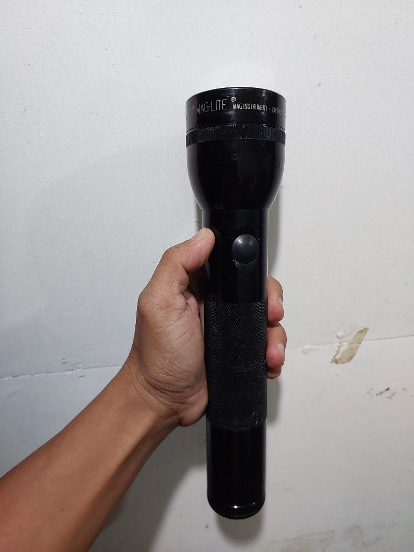 Maglite Flashlight (Category: Everything Else Others) located in Quezon City. Submitted by jpnvintageonline (Listing ID 1413780788, Image 1). Description: - Black Maglite flashlight - Textured grip for secure handling - Simple push-button on/off switch - Features the Maglite brand name - Shows size and shape in hand.