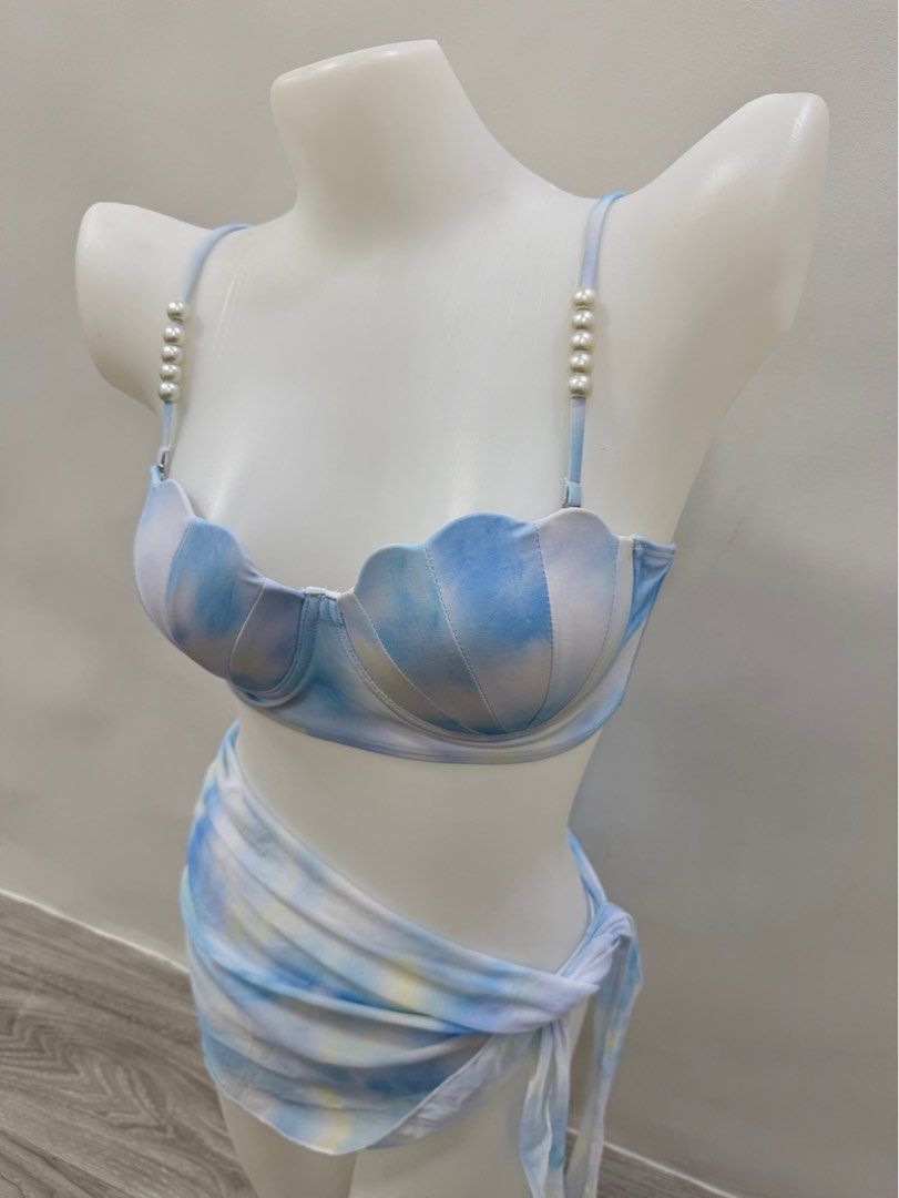 Mermaid Shell Two-Piece Swimsuit with Sarong (Category: Bikinis & Swimsuits) located in Taguig. Submitted by gelpingol (Listing ID 1413821957, Image 1). Description: - Mermaid shell bikini set - Can fit to S-M - Features pearl-detailed straps - Includes bikini top, bottom, and matching sarong - Blue and white tie-dye fabric - Scalloped edge on top - Adjustable straps - Sarong can be styled in multiple ways.