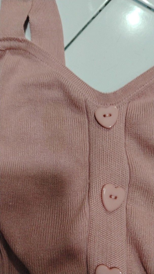 Pink Knitted Top with Heart Buttons (Category: Sleeveless) located in Manila. Submitted by loveeroded (Listing ID 1413764061, Image 2). Description: Can fit S to M. Pink knitted top features a V-neckline and heart-shaped buttons down the front. It has thick straps and a ribbed hem. With light stain (seen on pic). The top is a solid pink color. A cute and stylish addition to any wardrobe..