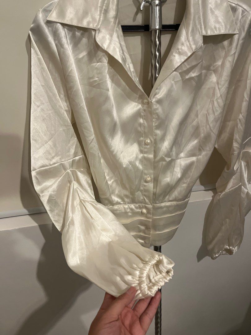 Reworked Cream Satin Blouse with Tie Back (Category: Blouses) located in San Pedro. Submitted by danasabfl (Listing ID 1413783728, Image 2). Description: - Elegant cream satin blouse - Collared neckline - Button-down front - Long sleeves with gathered cuffs - Fitted waist - Tie-back detail for adjustable fit - Unique back design - Perfect for a sophisticated look.