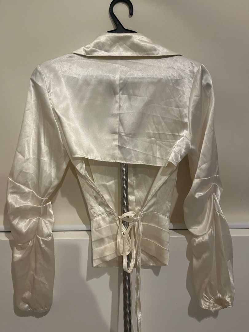 Reworked Cream Satin Blouse with Tie Back (Category: Blouses) located in San Pedro. Submitted by danasabfl (Listing ID 1413783728, Image 3). Description: - Elegant cream satin blouse - Collared neckline - Button-down front - Long sleeves with gathered cuffs - Fitted waist - Tie-back detail for adjustable fit - Unique back design - Perfect for a sophisticated look.
