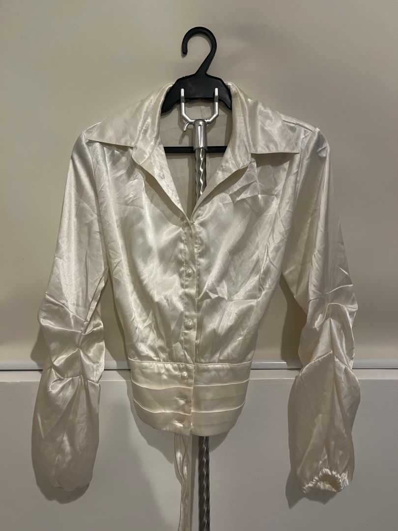 Reworked Cream Satin Blouse with Tie Back (Category: Blouses) located in San Pedro. Submitted by danasabfl (Listing ID 1413783728, Image 1). Description: - Elegant cream satin blouse - Collared neckline - Button-down front - Long sleeves with gathered cuffs - Fitted waist - Tie-back detail for adjustable fit - Unique back design - Perfect for a sophisticated look.