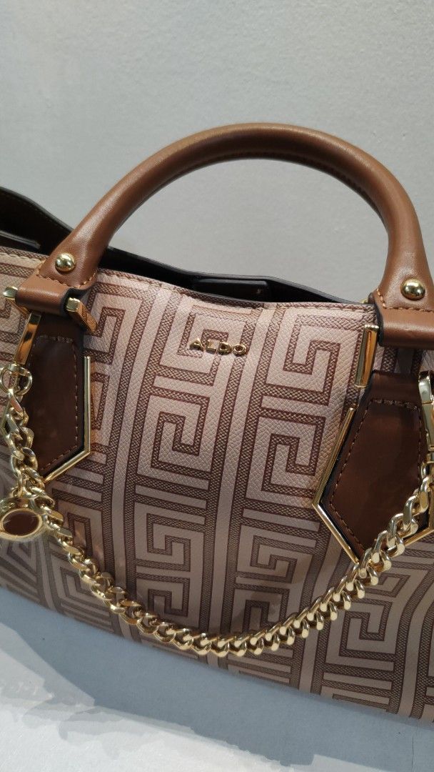 Aldo Handbag with Chain Detail (Category: Cross-body Bags) located in Manila. Submitted by _sinigurl (Listing ID 1413971861, Image 3). Description: - Aldo handbag with a stylish geometric design. - Brown handles and a detachable shoulder strap. - Includes a gold chain detail and charm. - Spacious interior for daily essentials.