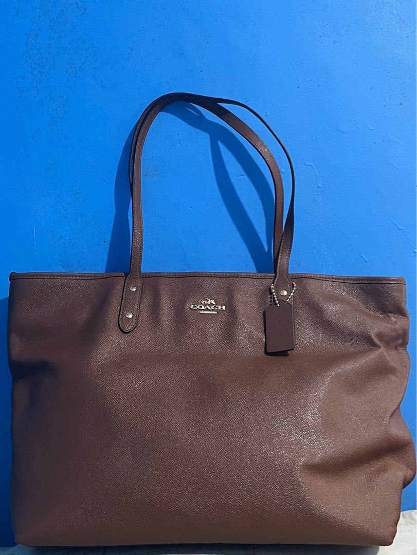 Coach Brown Tote Bag (XL) (Category: Luxury Bags & Wallets) located in Naga. Submitted by empanadaaaaaa (Listing ID 1413940073, Image 1). Description: - Brown Coach tote bag - Spacious interior with multiple compartments - Secure zip closure - Includes a Coach hang tag - Comfortable double handles - Features a Coach label inside - Classic solid brown color -Perfect Bag for school :) Please dm me if you need more photos or information about the ba