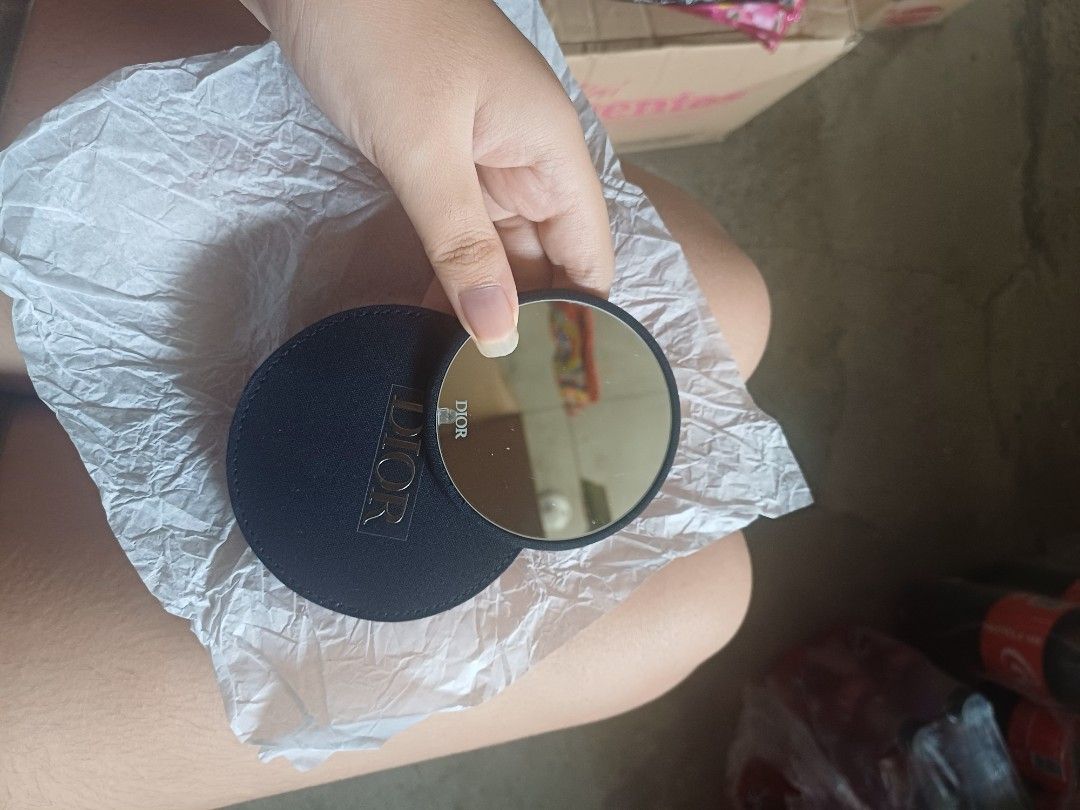 Dior Compact Mirror (Category: Face Care) located in Caloocan City. Submitted by feldsparky89171 (Listing ID 1413999333, Image 2). Description: Dior compact mirror. The mirror is round and has a black fabric exterior with the Dior logo. It comes with a matching black fabric case. The mirror is small and portable, perfect for on-the-go touch-ups..