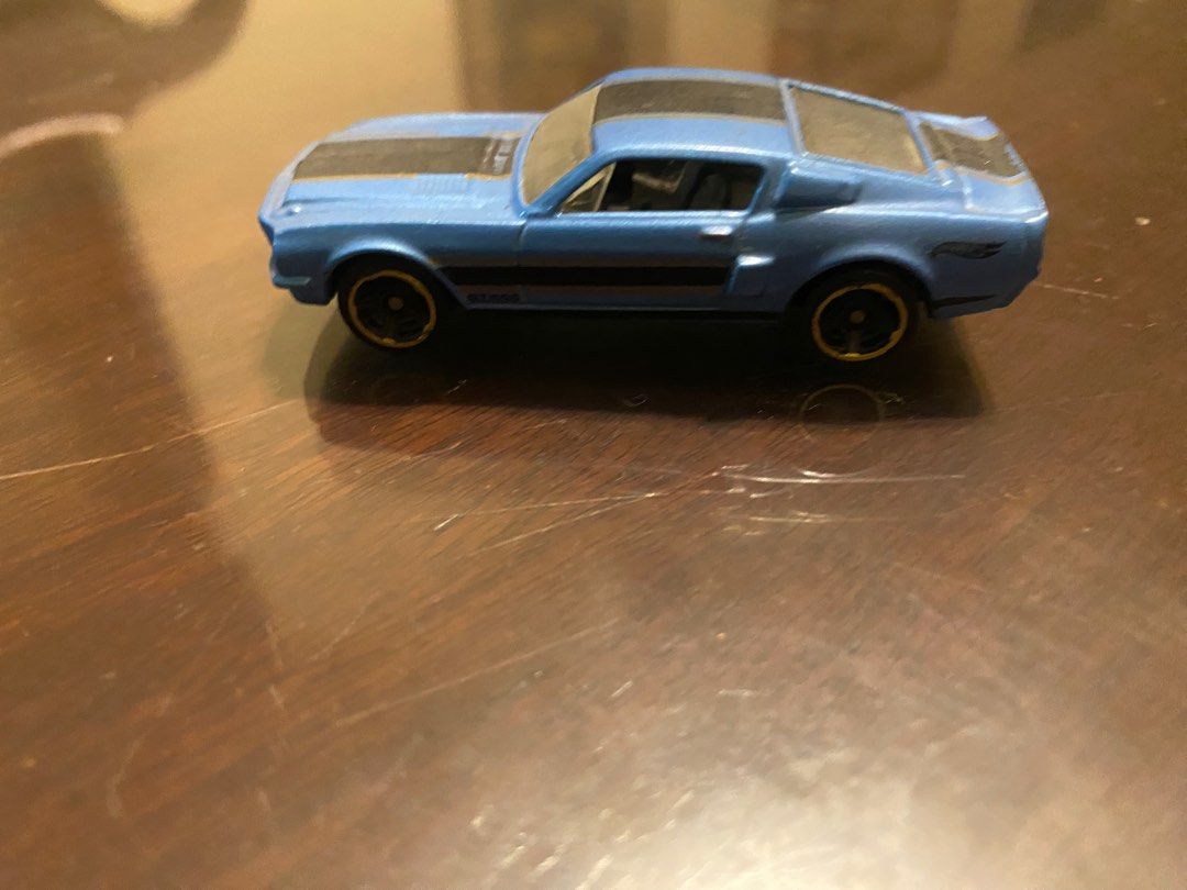Hot Wheels Shelby GT500 (Category: Vehicle & Diecast Models) located in Pasig City. Submitted by ecochicsales (Listing ID 1413876895, Image 1). Description: - Hot Wheels Shelby GT500 diecast car - Color: Blue - Features black stripes on hood and roof - Underside: 2012 Mattel details - Wheels: Black with gold rims - Classic collectible toy car.