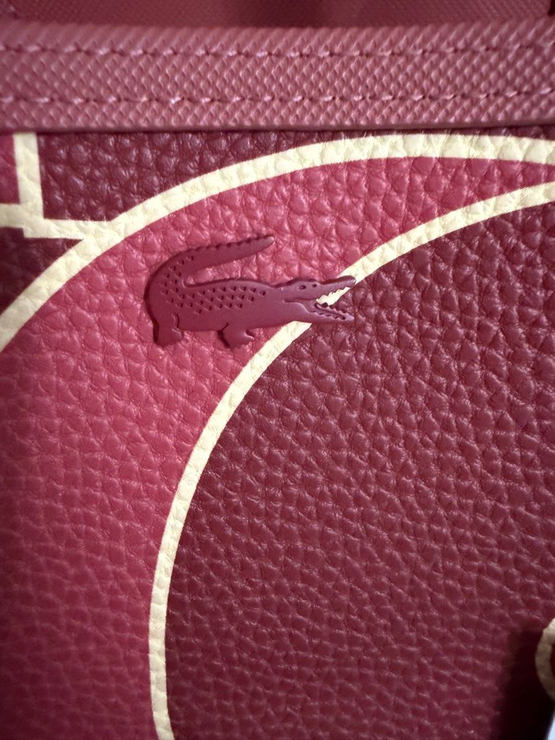 Lacoste (Category: Tote Bags) located in Manila. Submitted by pickstuff (Listing ID 1413888634, Image 3). Description: - Authentic Lacoste - Reversible - Unique maroon and pink pattern - Includes dust bag - Made of polyvinyl chloride (PVC) -Lacoste paper bag no longer available -cover for bag handle no longer available - Includes pouch - Lacoste logo visible on bag and dust bag.