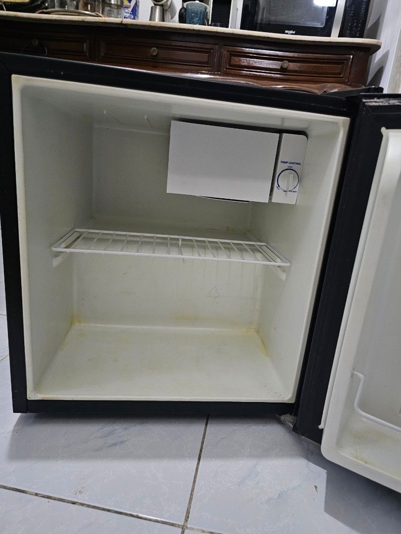 Mini Ref / Fridge American Home (Category: Refrigerators and Freezers) located in Kawit. Submitted by febcate (Listing ID 1413947741, Image 2). Description: Compact black mini fridge, perfect for small spaces. Features an interior shelf and a small freezer compartment. The door has a storage area. Ideal for keeping drinks and snacks cold. height 18 inches, width 18 inches open for meet up within Cavite, Las Pinas, Taguig, Makati. lalmove delivery