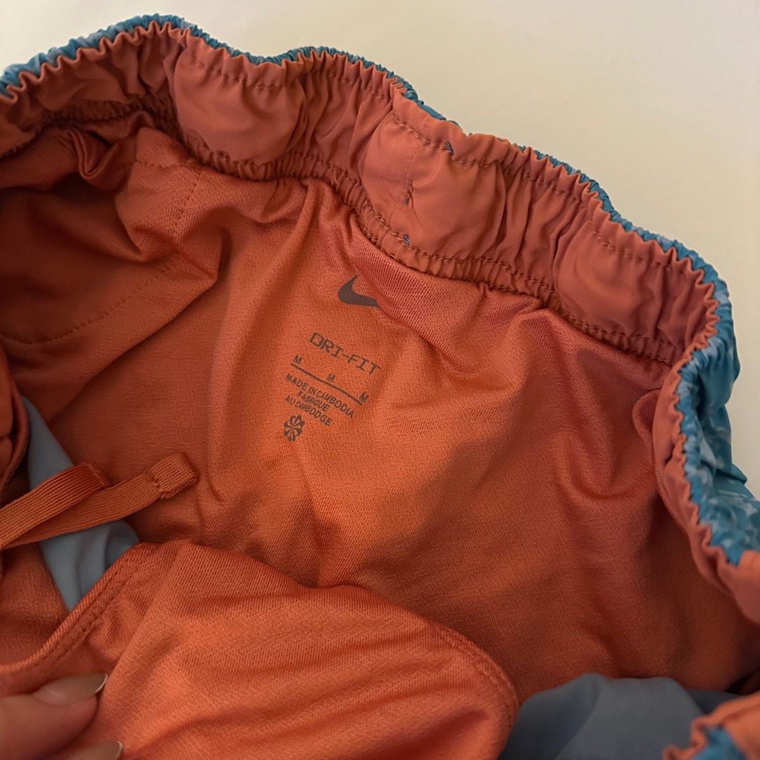 Nike Dri-FIT Running Shorts (Category: Activewear) located in Makati City. Submitted by marcheu (Listing ID 1414052547, Image 2). Description: - Nike Dri-FIT running shorts - Color: Blue with orange trim - Size: Medium (M) - Features: White Nike logo, inner lining, and elastic waistband - Has panty.
