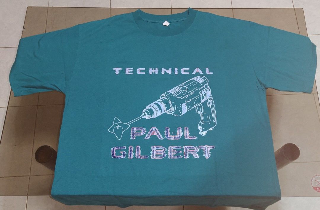 Paul Gilbert Graphic T-shirt (Category: Tshirts & Polo Shirts ) located in Ligao. Submitted by travis40 (Listing ID 1413952687, Image 2). Description: - Teal T-shirt - Features a graphic design with "TECHNICAL" and "PAUL GILBERT" and a drill image. - White print - Crew neck - Standard fit.