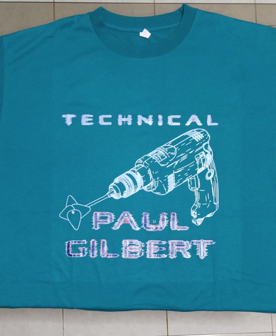 Paul Gilbert Graphic T-shirt (Category: Tshirts & Polo Shirts ) located in Ligao. Submitted by travis40 (Listing ID 1413952687, Image 1). Description: - Teal T-shirt - Features a graphic design with "TECHNICAL" and "PAUL GILBERT" and a drill image. - White print - Crew neck - Standard fit.