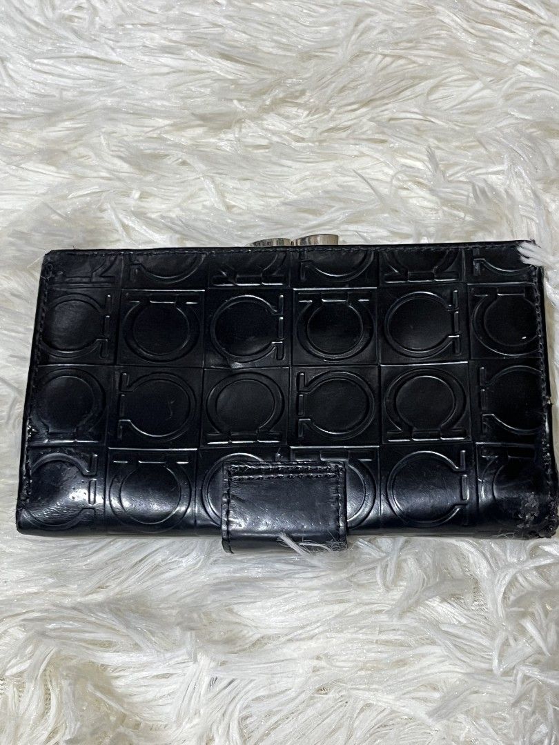 Salvatore Ferragamo Black Wallet (Category: Luxury Bags & Wallets) located in Mati. Submitted by CrestChancebyIFT (Listing ID 1414047138, Image 2). Description: - Black Salvatore Ferragamo wallet - Clasp closure - Textured pattern with logo - Multiple compartments for cards and cash - Clear ID window - Snap closure - Small flap with brand name.