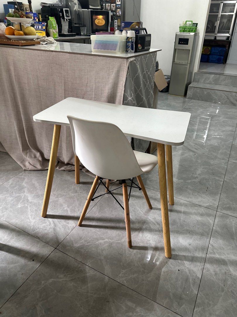 Scandinavian White Table and Chair Set (Category: Tables & Sets) located in San Juan City. Submitted by unclutterermnl (Listing ID 1413867936, Image 2). Description: - White table with wooden legs - White chair included - Table shape: Rectangular with rounded corners - Chair design: Modern with white seat and wooden legs with black metal support - Perfect for small spaces or as a desk -Needs cleaning.