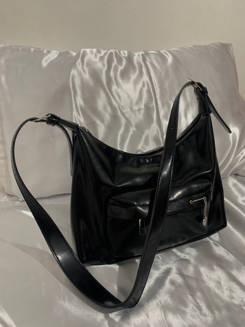 TALA - Black Shoulder Bag with Heart Charm (Category: Shoulder Bags) located in Manila. Submitted by ayarayaaa (Listing ID 1413939961, Image 1). Description: - Sleek black shoulder bag - Glossy finish - Front pocket with silver zipper - Decorative heart charm - Long, adjustable strap - Smooth, possibly synthetic material.