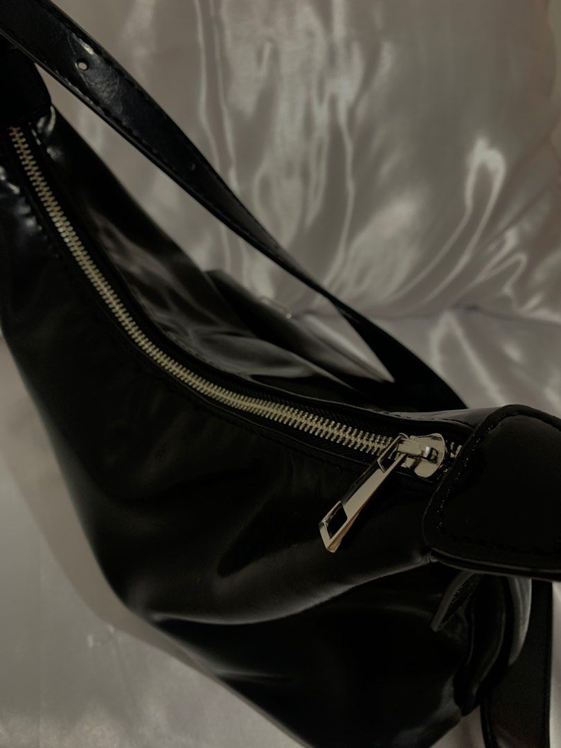 TALA - Black Shoulder Bag with Heart Charm (Category: Shoulder Bags) located in Manila. Submitted by ayarayaaa (Listing ID 1413939961, Image 3). Description: - Sleek black shoulder bag - Glossy finish - Front pocket with silver zipper - Decorative heart charm - Long, adjustable strap - Smooth, possibly synthetic material.