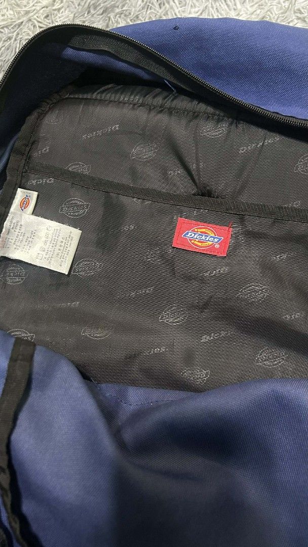 Dickies Backpack (Category: Backpacks) located in Manila. Submitted by orlacoyam89725 (Listing ID 1414169465, Image 2). Description: - Dickies backpack - Color: Blue and Black - Front pocket - Side pockets - Adjustable shoulder straps - Interior: Dickies logo pattern - Condition: Minor tear on one shoulder strap - Perfect for everyday use.