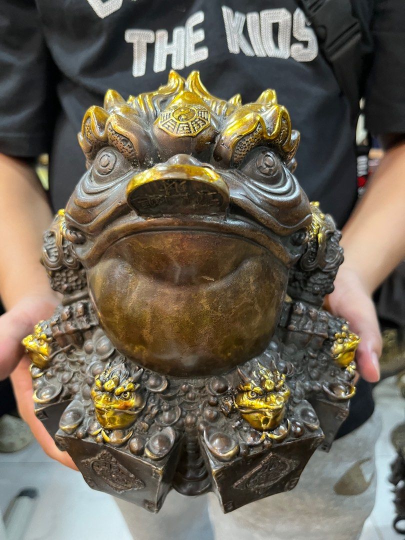 DMVs - Feng Shui Wealth Frog Figurine (Category: Other Home Decor) located in Manila. Submitted by vintage_styles_co (Listing ID 1414242337, Image 3). Description: Check out this DMVs Feng Shui Wealth Frog! This detailed figurine is perfect for bringing good vibes to your home or office. It features the classic frog with a coin in its mouth, surrounded by smaller frog figures, all with beautiful gold accents. Meetups available at SM Sta Mesa, McD