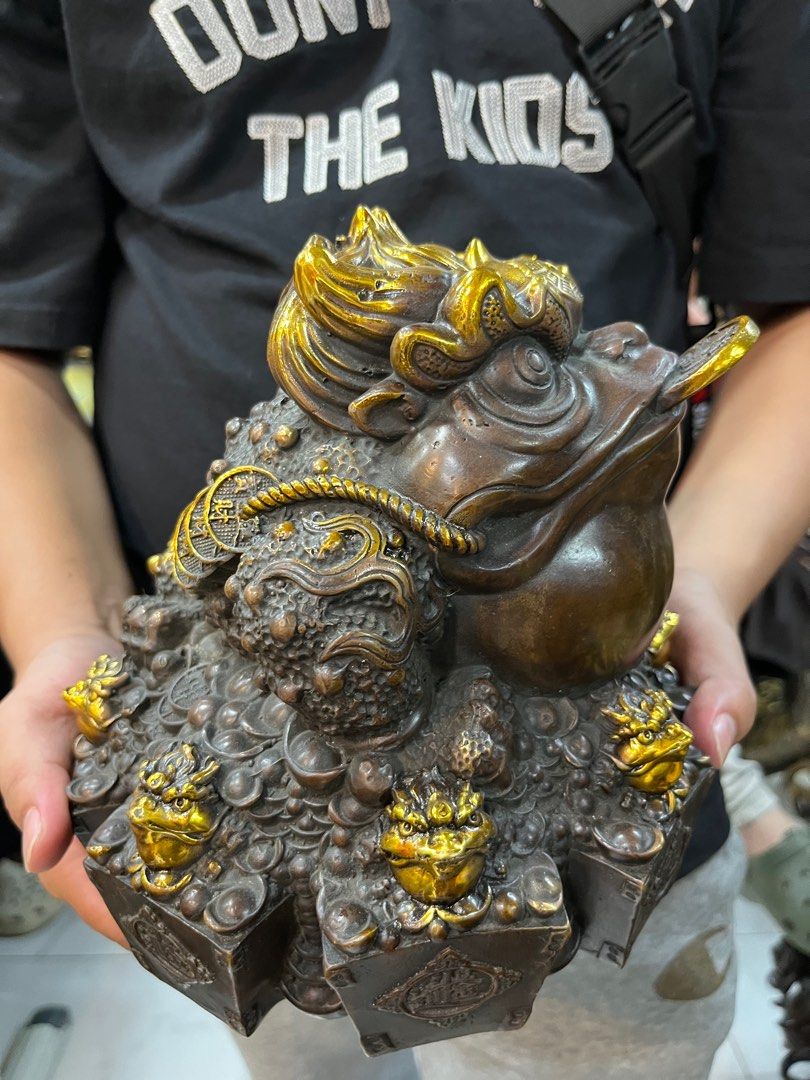 DMVs - Feng Shui Wealth Frog Figurine (Category: Other Home Decor) located in Manila. Submitted by vintage_styles_co (Listing ID 1414242337, Image 2). Description: Check out this DMVs Feng Shui Wealth Frog! This detailed figurine is perfect for bringing good vibes to your home or office. It features the classic frog with a coin in its mouth, surrounded by smaller frog figures, all with beautiful gold accents. Meetups available at SM Sta Mesa, McD