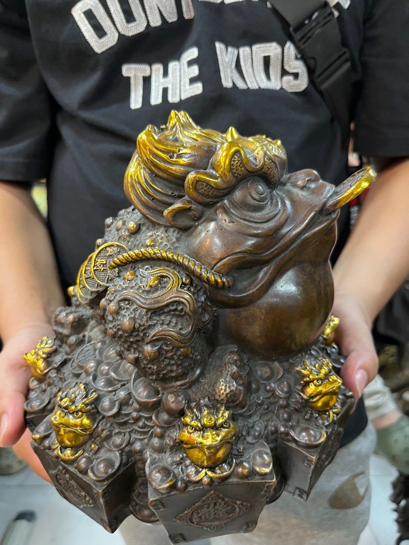 DMVs - Feng Shui Wealth Frog Figurine (Category: Other Home Decor) located in Manila. Submitted by vintage_styles_co (Listing ID 1414242337, Image 1). Description: Check out this DMVs Feng Shui Wealth Frog! This detailed figurine is perfect for bringing good vibes to your home or office. It features the classic frog with a coin in its mouth, surrounded by smaller frog figures, all with beautiful gold accents. Meetups available at SM Sta Mesa, McD