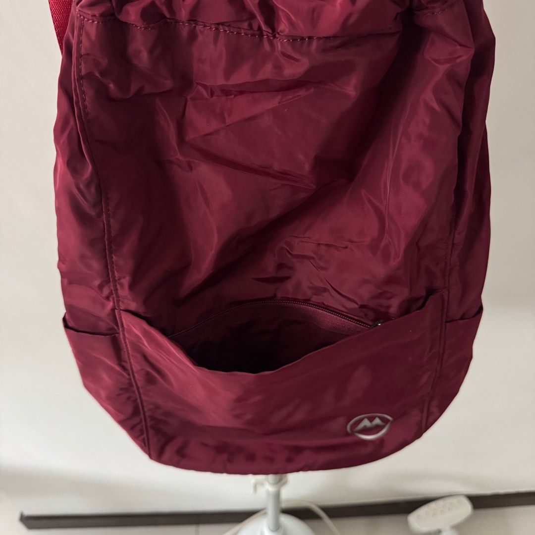 Drawstring Bag (Category: Backpacks) located in Manila. Submitted by declutterzoneee (Listing ID 1414085979, Image 2). Description: - Drawstring backpack - Deep red color - Front pocket - Two side pockets - Interior zippered pocket - Adjustable shoulder straps - Lightweight, possibly nylon material - Drawstring closure.