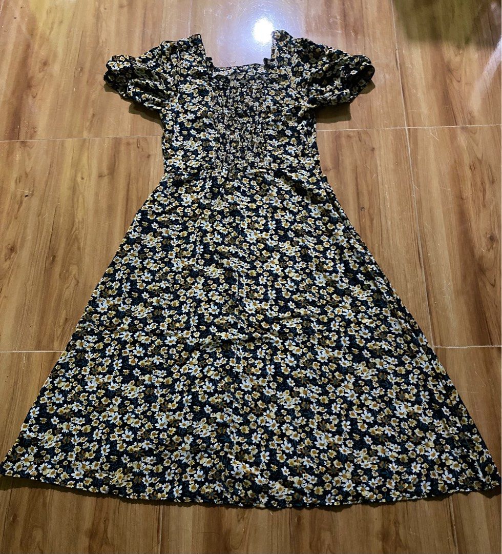Floral Midi Dress (Category: Dresses) located in Cagayan de Oro. Submitted by ecolive (Listing ID 1414064648, Image 1). Description: Midi dress features a square neckline and short sleeves. It has a fitted bodice with a gathered detail and a flared skirt. The dress is adorned with a floral pattern in white, yellow, and green on a black background..